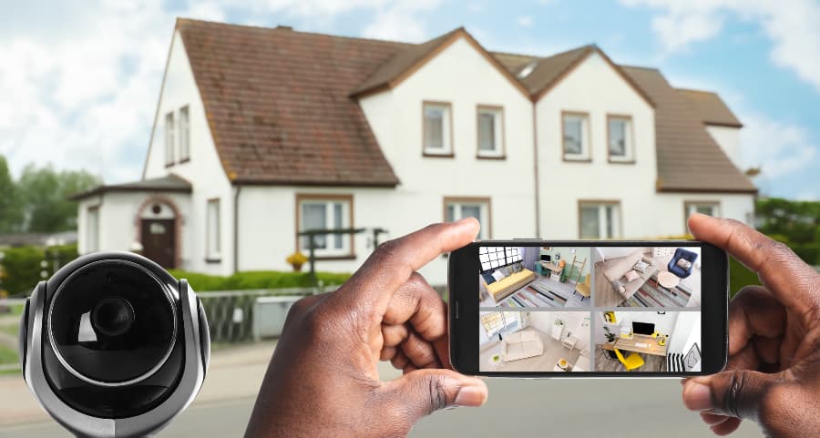 Man holding mobile device and viewing streams from video cameras